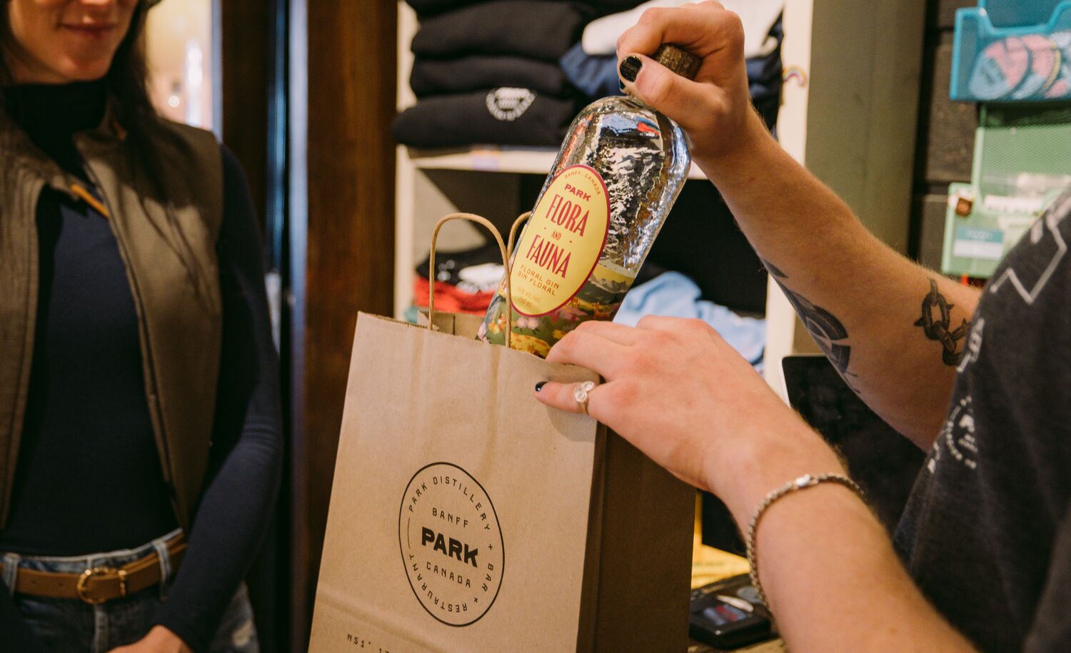 A woman buys a bottle of gin at the PARK Distillery retail store. 
